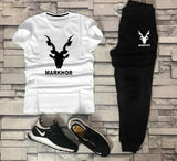White t-shirt and black pants with 'Markhor' branding on a stone wall background